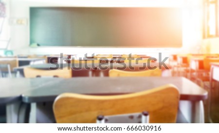 School classroom in blur background without young student; Blurry view of elementary class room no kid or teacher with chairs and tables in campus.