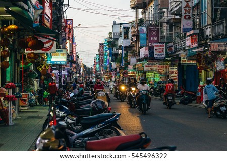 HUE, VIETNAM, 28 DECEMBER 2016 : Evening view of colorful Hue city street as people ride on the motorbikes passing by .