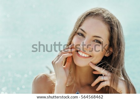 beautiful smiling girl on a blue sky background face close up
