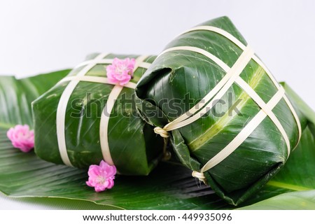 Uncooked Vietnamese Chung Cake isolated on white. It's a square glutinous sticky rice cake, stuffed with pork meat, green beans and wrapped in bamboo leaf. Traditional Vietnamese New Year (Tet) food.