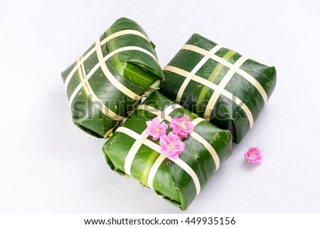 Uncooked Vietnamese Chung Cake isolated on white. It's a square glutinous sticky rice cake, stuffed with pork meat, green beans and wrapped in bamboo leaf. Traditional Vietnamese New Year (Tet) food.