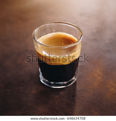 A Cup Of Espresso Shot Coffee By Barista In Glass On Rust Table Background A Cup Of Espresso Shot Coffee By Barista In Glass On Rust Table Background
