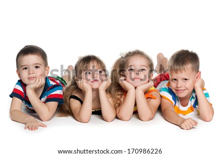 Four preschool children are lying on the floor on the white background