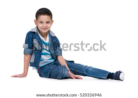 A handsome little boy sits on the white background