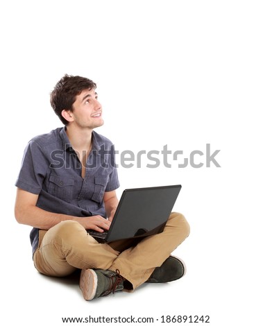 portrait of happy young man sitting while using laptop computer on white background