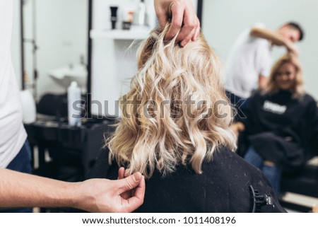 Beautiful hairstyle of young woman after dying hair and making highlights in hair salon.