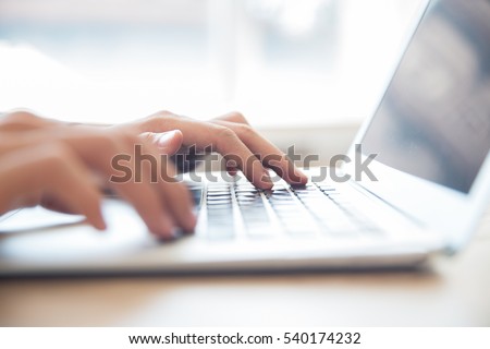 Close-up of male hands typing on laptop keyboard