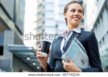 Portrait of business woman walking and smiling outdoor