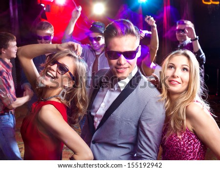 Group of young people dancing at the disco club - stock photo