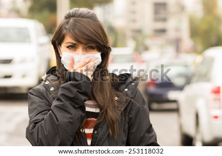 portrait of young girl walking wearing a mask in the city street concept of pollution