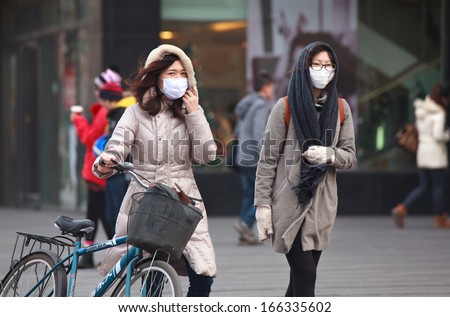 BEIJING-DEC 8: People with face masks are seen on Dec 8,2013 in Beijing, China. 104 cities in China suffered from severe air pollution on Dec7, Beijing was among that hit the hardest