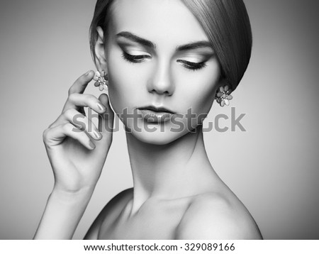 Portrait of beautiful sensual woman with elegant hairstyle. Perfect makeup. Blonde girl. Fashion photo. Jewelry. Black and white