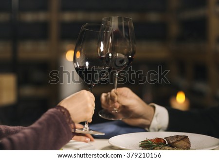 https://thumb9.shutterstock.com/display_pic_with_logo/499798/379210156/stock-photo-hand-of-man-and-woman-sitting-in-a-restaurant-by-a-table-and-holding-glasses-with-wine-shelves-379210156.jpg