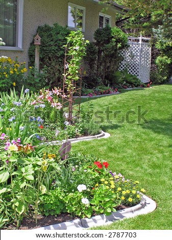 Curving perennial bed in a sunny side garden.