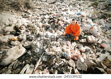 Portrait of recycling worker among garbage bags on the landfill