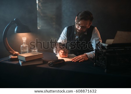 Bearded writer in glasses writes with a feather