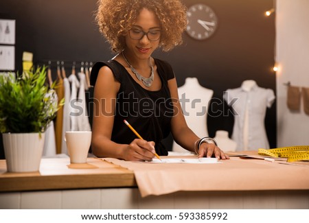 A young fashion designer working on her atelier