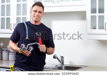 Plumber man with tools in the kitchen. Plumbing and renovation.