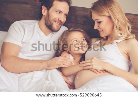 https://thumb9.shutterstock.com/display_pic_with_logo/559060/529090645/stock-photo-beautiful-pregnant-woman-her-handsome-husband-and-cute-little-daughter-are-talking-and-smiling-529090645.jpg