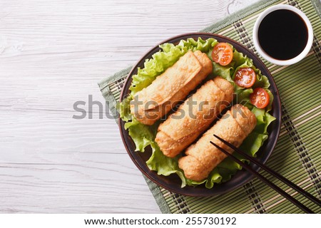 fried spring rolls on a plate with salad, horizontal view from above