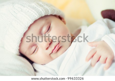 picture of a newborn baby curled up sleeping on a blanket