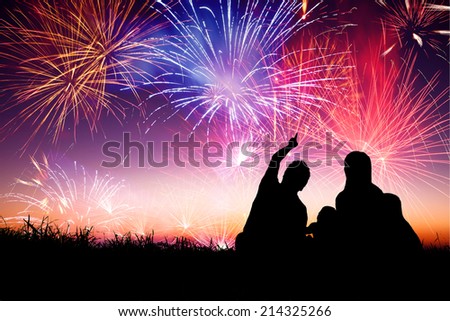 happy family sitting on floor and watching the fireworks