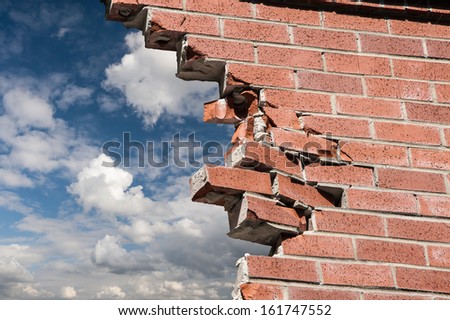 stock-photo-broken-brick-wall-and-blue-s