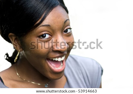 A happy or surprised young black woman isolated over a white background.  Clipping path is included for easy isolation.