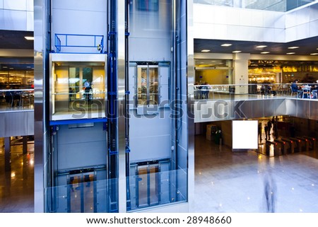 People in blue hall window in exposition center, square copmosition
