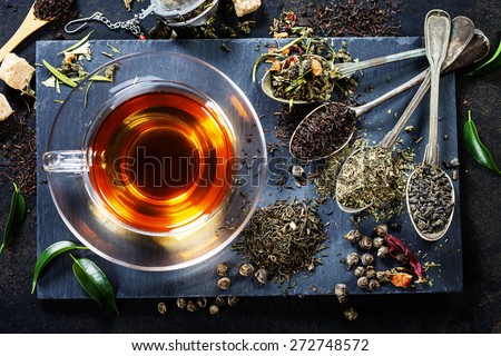 Tea composition with old spoon on dark background