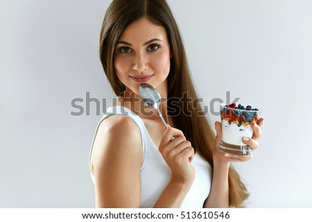Woman On Healthy Diet. Closeup Of Beautiful Cheerful Girl With Glass Of Natural Yogurt, Delicious Berries ( Blueberry, Goji, Raspberries ) And Oatmeal, Granola. Organic Nutrition. High Resolution