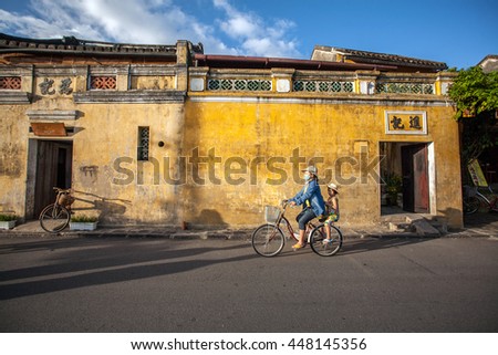 HOI AN, VIETNAM - OCTOBER 21: Unidentified Vietnamese cycling at riverfront of Hoi An old town. it was declared a World Heritage Site by UNESCO on Oct 21, 2014 in Hoi An, Vietnam