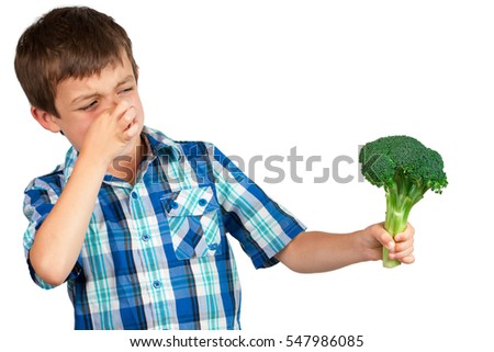 Small boy staring at a bunch of broccoli with disgust