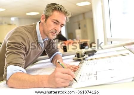 Architect working on drawing table in office