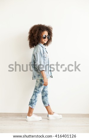 Beautiful stylish little girl in jean clothes