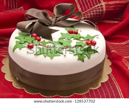 Christmas cake decorated with fondant holly leaves - stock photo