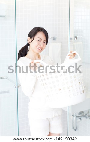 beautiful young woman carrying laundry basket