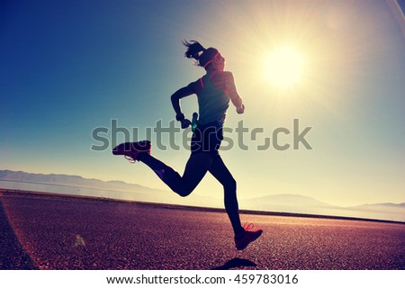 young fitness woman runner running on sunrise seaside trail
