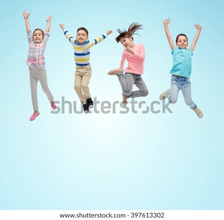 happiness, childhood, freedom, movement and people concept - happy little children jumping in air over blue background