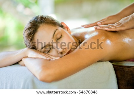 An attractive caucasian woman lying down on a massage bed at a spa