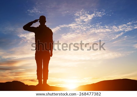Soldier salute. Silhouette on sunset sky. War, army, military, guard concept.