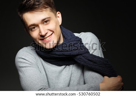 Sexy young man in warm knit sweateron with a cup of tea in his hands. Male model.
