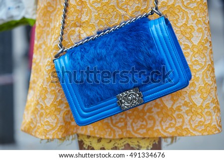 MILAN - SEPTEMBER 21: Woman with blue Chanel bag with fur and yellow floral coat before Gucci fashion show, Milan Fashion Week street style on September 21, 2016 in Milan.