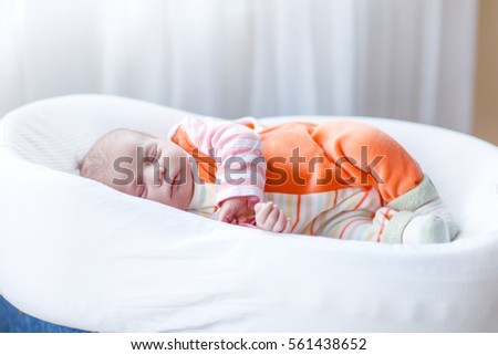 Cute adorable newborn baby sleeping peaceful in bed. New born child, little girl laying in bed. Family, new life, childhood, beginning concept.