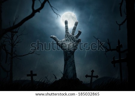 Halloween concept, zombie hand rising out from the ground Halloween concept, zombie hand rising out from the ground