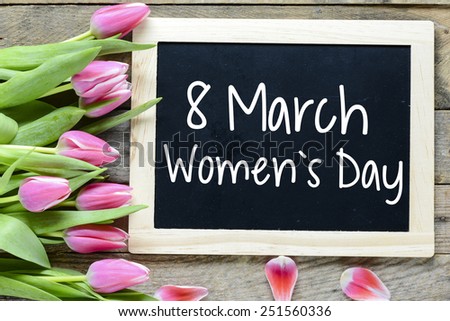 Happy Women's Day with tulips. Happy Women's Day on blackboard with pink tulips