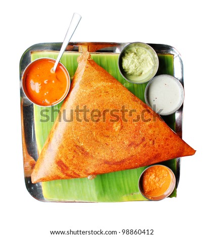 Popular south indian breakfast dosa in golden brown color with 3 types of chutney and sambar - stock photo