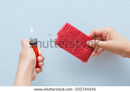 Red firecrackers and a lighter in hand, dangerous