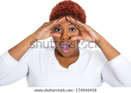 Closeup portrait of young beautiful shocked woman looking through her fingers like binoculars, searching for something, looking for the future at camera, isolated white background. Emotion feelings
