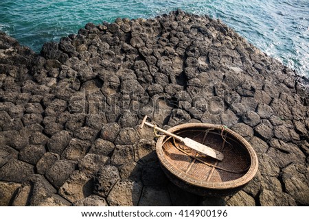Traditional vietnamese boat on the basalt rocks formation, Da Dia Reef, Vietnam